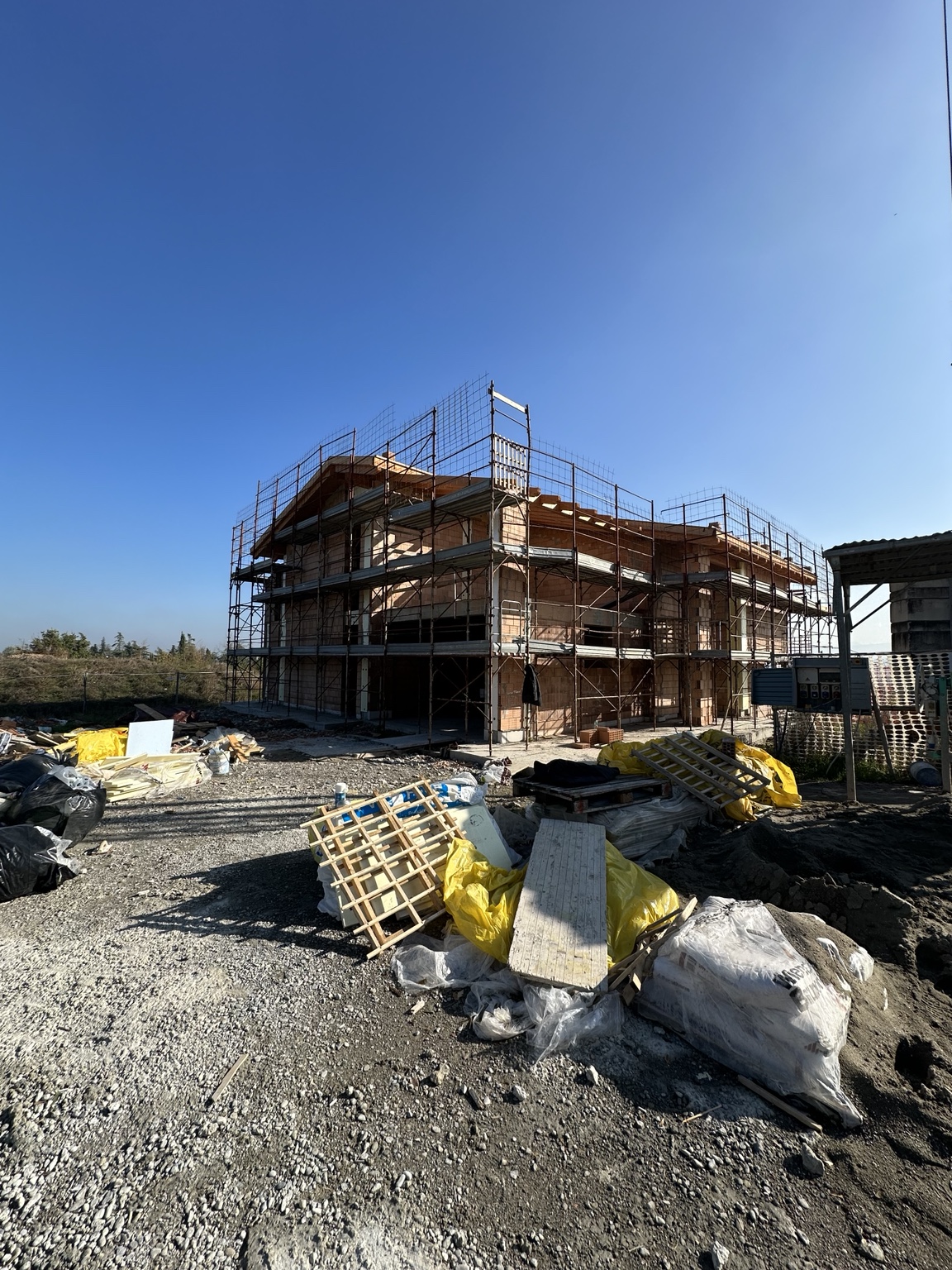 Vista del cantiere con murature e ponteggi.